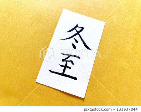 一張用毛筆寫著「冬至」字樣的紙片被放置在柚子色的紙片上。 133937844