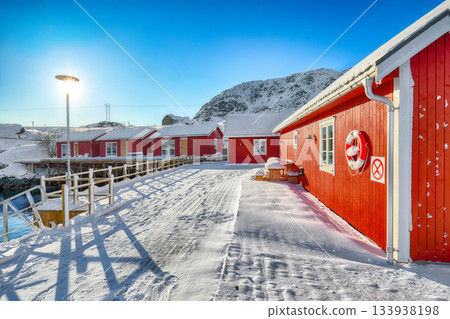 Amazing scenery with traditional Norwegian red wooden houses on the shore of Sundstraumen strait. Amazing scenery with traditional Norwegian red wooden houses on the shore of Sundstraumen strait. 133938198