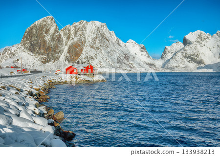 Traditional Norwegian houses on the shore of Reinefjorden on Toppoya island and snowy mountaines in background Traditional Norwegian houses on the shore of Reinefjorden on Toppoya island and snowy mountaines in background 133938213