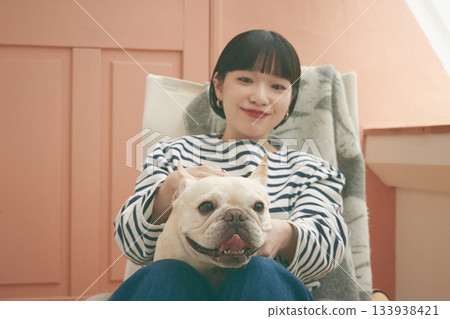 A woman sitting in a chair and a dog A woman sitting in a chair and a dog 133938421