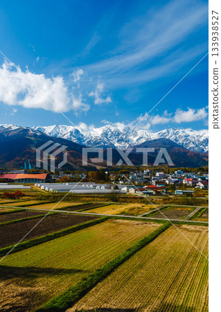 Hakuba Village and the Hakuba Mountains, covered in three layers of autumn foliage after the snow Hakuba Village and the Hakuba Mountains, covered in three layers of autumn foliage after the snow 133938527