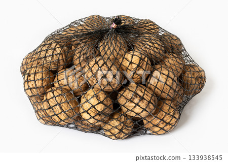 Walnuts in a black mesh bag packaging isolated on white background Walnuts in a black mesh bag packaging isolated on white background 133938545