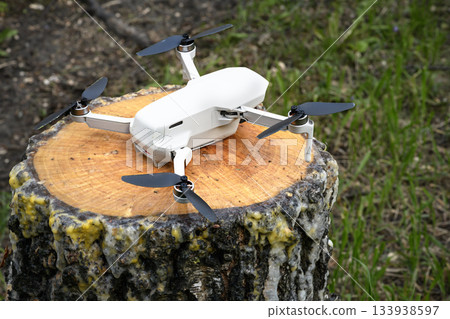 Small Quadcopter Drone copter parked on a birch tree stump rainy weather Small Quadcopter Drone copter parked on a birch tree stump rainy weather 133938597