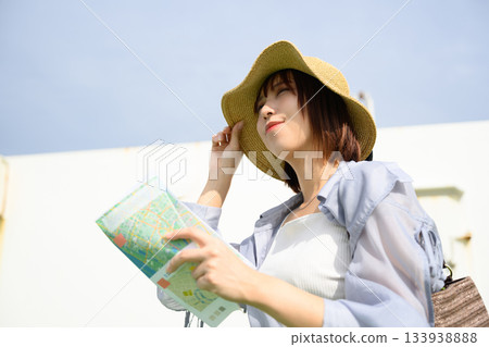 Woman in straw hat looking at map on board Woman in straw hat looking at map on board 133938888