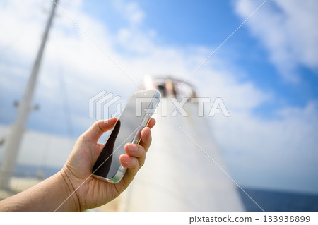 一名女子在機上操作智慧型手機 一名女子在機上操作智慧型手機 133938899