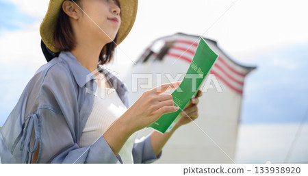 戴帽子的女人正在看地圖 133938920