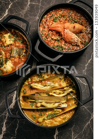 Portuguese traditional food fish soup and seafood risotto meal on restaurant table in lisbon Portuguese traditional food fish soup and seafood risotto meal on restaurant table in lisbon 133939049