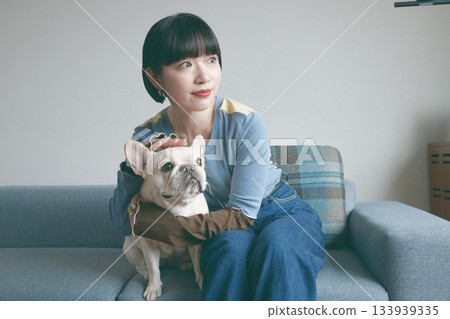 A young woman and a dog relaxing on the sofa A young woman and a dog relaxing on the sofa 133939335