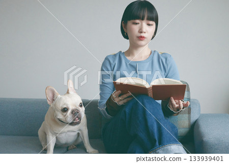女人和狗在沙發上看書 133939401