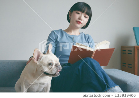 女人和狗在沙發上看書 133939406