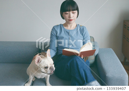 女人和狗在沙發上看書 女人和狗在沙發上看書 133939407