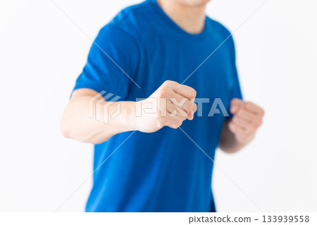 A middle-aged man in a T-shirt taking a martial arts stance 133939558