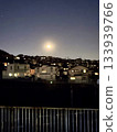 A fantastic night view of the full moon rising over a residential area at dusk 133939766