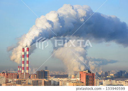 Fuming industrial tubes chimneys smoke heating station big city blue sky 133940599