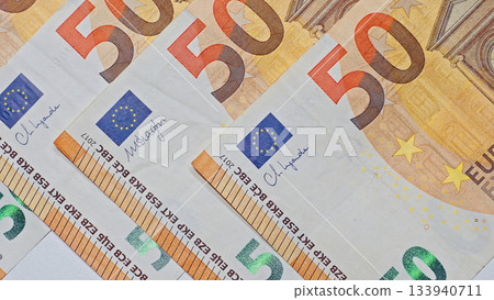 Closeup view of euro banknotes arranged in an overlapping pattern, showcasing European money for financial backgrounds. 133940711