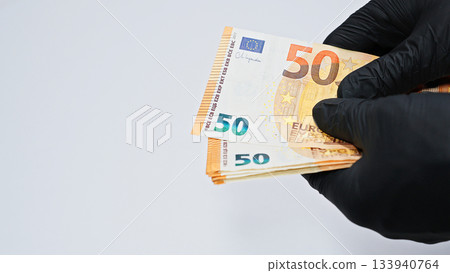 Close-up of hands in black gloves counting euro banknotes, symbolizing crime, corruption, money laundering, illegal finance, and underworld economic activities. Close-up of hands in black gloves counting euro banknotes, symbolizing crime, corruption, money laundering, illegal finance, and underworld economic activities. 133940764