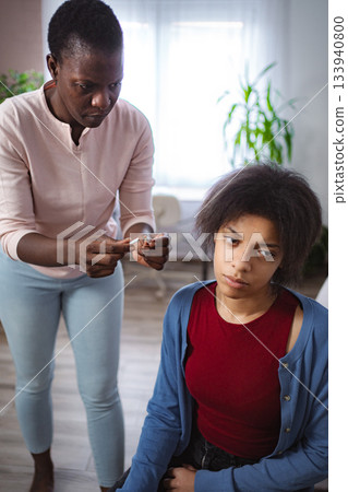 Mother breaking cigarette and showing her teenage daughter dangers of smoking Mother breaking cigarette and showing her teenage daughter dangers of smoking 133940800