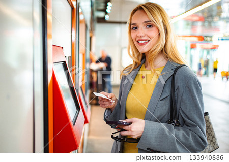 Woman smiling buying ticket with credit card at station 133940886
