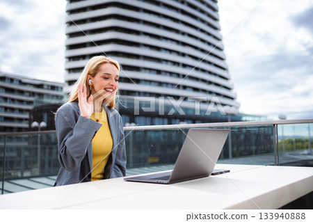 Woman working remotely during video call outdoors Woman working remotely during video call outdoors 133940888