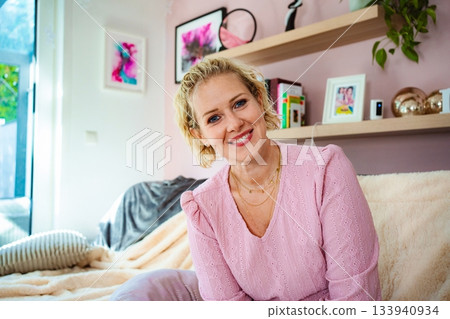 Woman smiling at home relaxing on couch 133940934