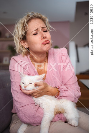 Woman holding cat with funny sad crying facial expression 133940939