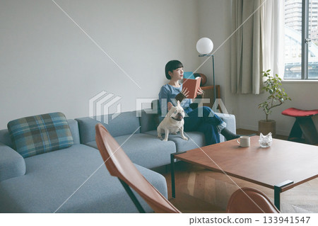 女人和狗在沙發上放鬆 女人和狗在沙發上放鬆 133941547