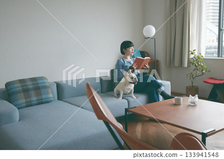 Woman and dog relaxing on sofa 133941548