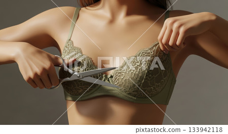 Conceptual image of a woman preparing to cut her bra with scissors, symbolizing liberation and personal choice. Conceptual image of a woman preparing to cut her bra with scissors, symbolizing liberation and personal choice. 133942118