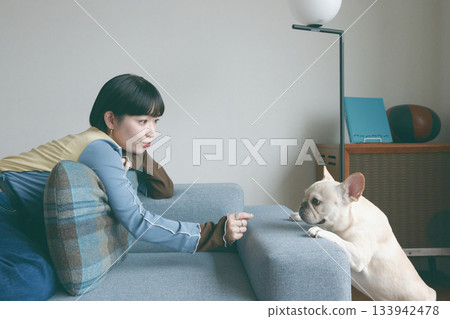 女人和狗在沙發上放鬆 133942478