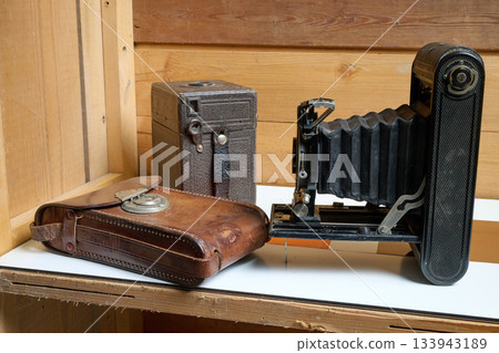 Old camera on a wooden shelf 133943189