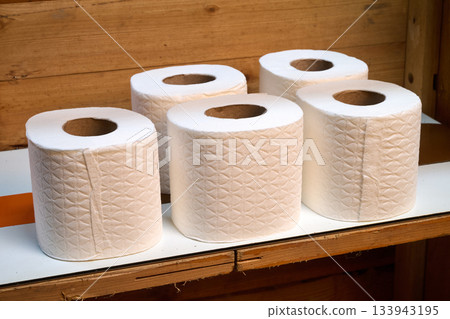 toilet paper rolls on a wooden shelf toilet paper rolls on a wooden shelf 133943195