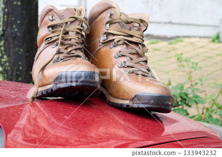 Outdoor. Pair of shoes on car capot 133943232