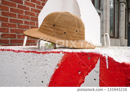 Outdoor. safari helmet on low wall 133943238