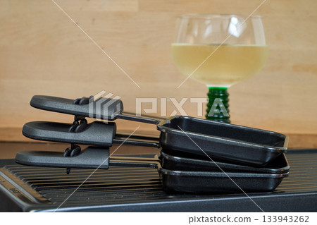 Raclette trays and wooden pallets on table Raclette trays and wooden pallets on table 133943262