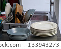 filled dish dryer and plates on counter 133943273