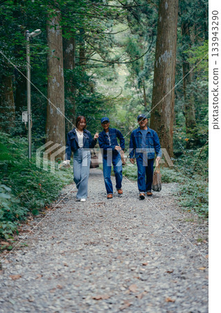 三個家長帶著孩子沿著林間小路散步的場景 133943290