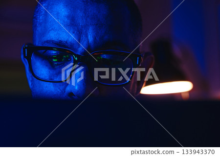 Person trading stocks and cryptocurrencies online at night 133943370