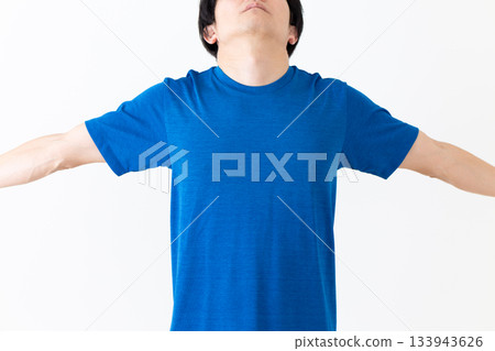 A middle-aged man wearing a T-shirt taking a deep breath A middle-aged man wearing a T-shirt taking a deep breath 133943626