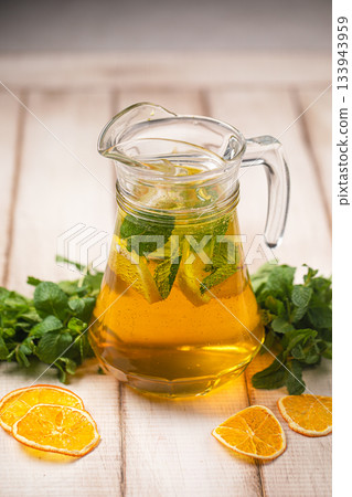 Refreshing citrus mint drink in glass pitcher 133943959