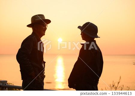 A middle-aged man talking to the sunset 133944613