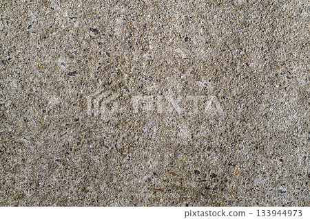 Concrete texture closeup with rough gray surface and embedded stones for background use in design 133944973