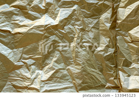 Crinkled gold foil texture as an abstract background with luminous metallic shine Crinkled gold foil texture as an abstract background with luminous metallic shine 133945123
