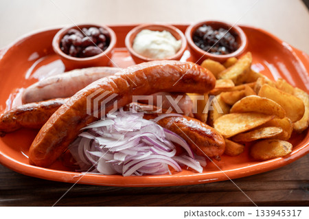 Savoring rich flavors of grilled sausages and tasty sides on a vibrant platter 133945317