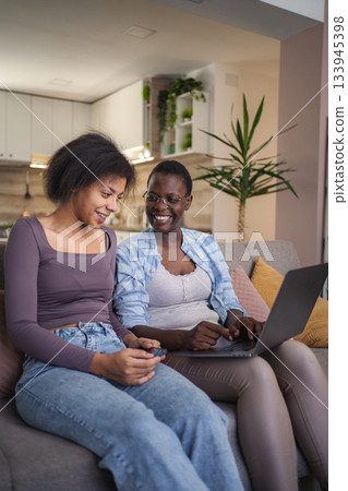 Mother and Daughter Using Laptop and Smartphone at Home 133945398