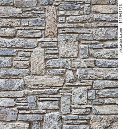 Rough textured stone wall with irregular masonry pattern and weathered stones, architectural detail Rough textured stone wall with irregular masonry pattern and weathered stones, architectural detail 133945718