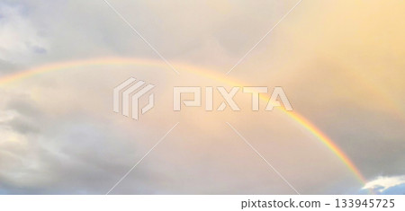 Rainbow across a warm sky over soft clouds, a serene moment of natural beauty Rainbow across a warm sky over soft clouds, a serene moment of natural beauty 133945725