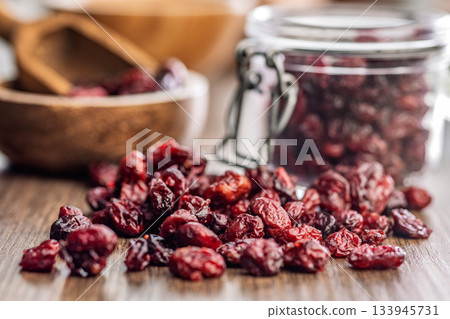 Tasty dried cranberries on wooden table. Tasty dried cranberries on wooden table. 133945731