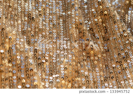 Gold sequin fabric backdrop with shimmering sparkle for fashion, party, and glamour shoots Gold sequin fabric backdrop with shimmering sparkle for fashion, party, and glamour shoots 133945752