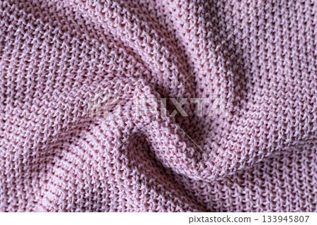 Close up of pink knitted fabric with soft texture and cozy woven pattern Close up of pink knitted fabric with soft texture and cozy woven pattern 133945807