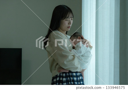 A mother holding a baby, tired from childcare after giving birth A mother holding a baby, tired from childcare after giving birth 133946575
